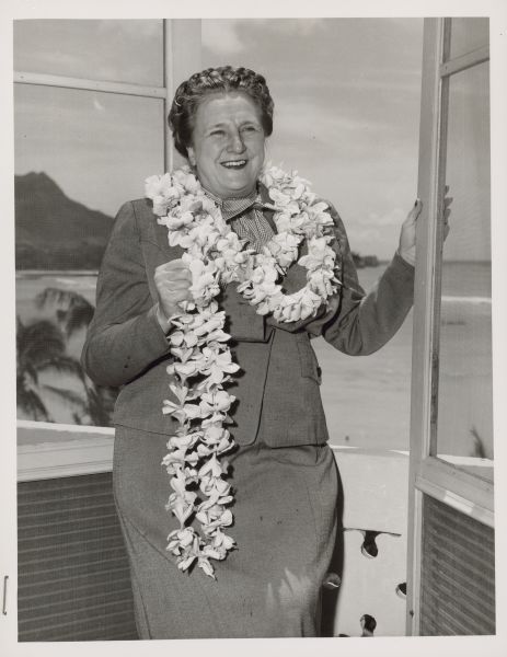 Typewritten note on Royal Hawaiian stationery reads: "Royal Hawaiian, Honolulu, Hawaii, U.S.A. Esther Van Wagoner Tufty, Washington D.C. war correspondent and news bureau head, takes a last look at Waikiki beach and Diamond Head from her lanai at the Royal Hawaiian hotel, where she spend [<i>sic</i>] several days, before taking off for Korea, where she will fly the air lift with wounded American soldiers, at the request of the Department of Defense. Miss Tufty hopes to stop off for another visit in Hawaii on her return from Korea and Japan. Royal Hawaiian Photo."