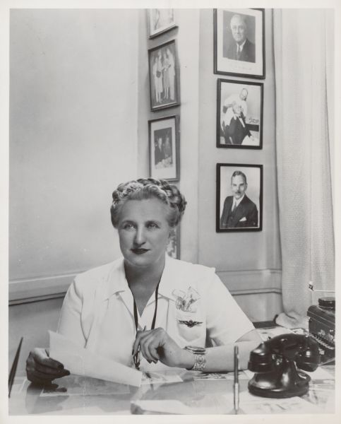 Portrait of Esther Van Wagoner Tufty sitting at a desk.