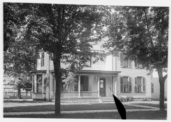 Text from negative sleeve: "Madison environ, Wisconsin, ca.1895-1905. Frame house. Urban house with shutters and flag posters (?) in bottom bay window and second story window. Andrew Dahl Collection. a gelatin plate, not by Andrew Dahl but form his collection."