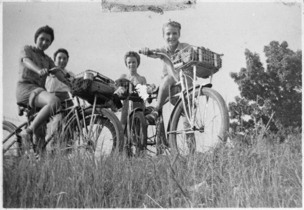 Frances Badoratto, Stella LaBruzzo, Vita Valenza, and Mary Lou Ciulla posed on their bicycles during a trip around Lake Mendota with the Neighborhood House American Youth Hostel group.