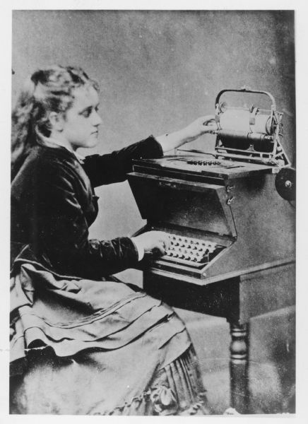 Lillian Sholes, demonstrating a prototype typewriter invented by her father, Christopher Latham Sholes.