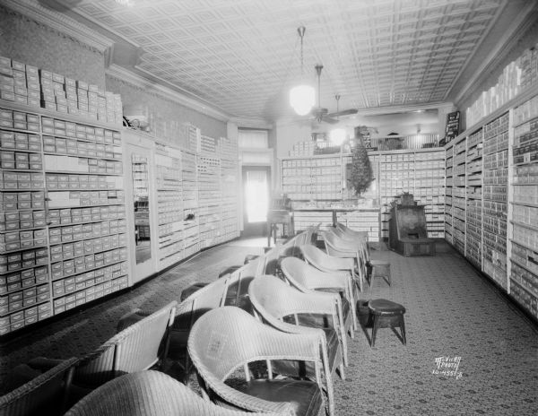 Huegel and Hyland Shoe Store, interior view, showing the x-ray machine in the background, 112 King Street. A stuffed peacock is on a shelf above the counter on the back wall near the entrance.