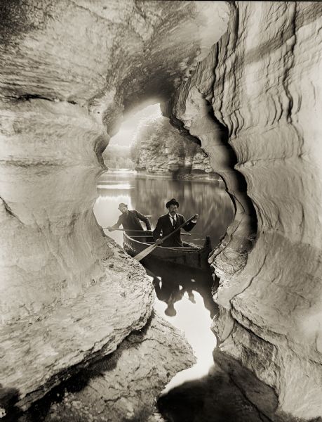 Two men navigating their canoe through caves at the Wisconsin Dells.