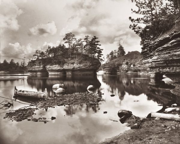 A view of Lone Rock from below, with a canoe on the left-hand side.