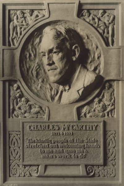 A plaque featuring the likeness of Charles McCarthy in a Celtic cross. The inscription reads: "'Charles McCarthy, 1873 + 1921. The kindly people of the State stretched out welcoming hands to me and gave me a man's work to do.'"
