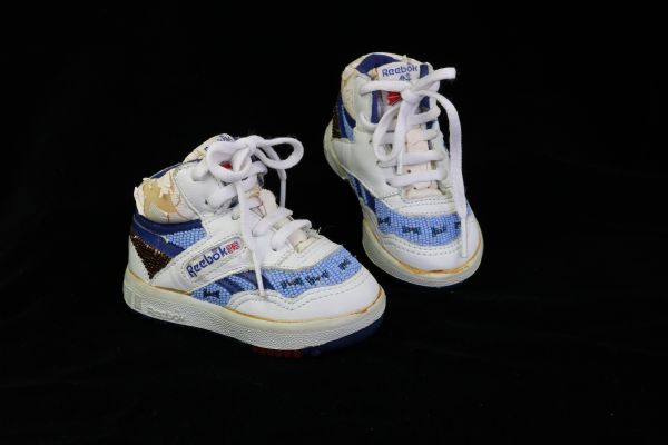 A pair of Reebok baby shoes, beaded by Ho-Chunk artist Linda Lucero. The beads are glass and the shoes were probably never worn.