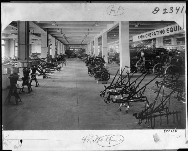 Display of agricultural equipment on the floor of a dealership. There are Titan tractor on the right under a sign for: "Farm Operating Equipment."