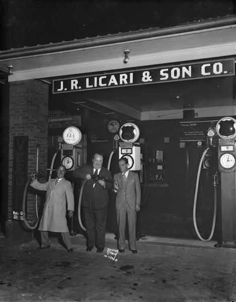 Three entertainers, Ben Turpin, Walter Hiers, and Snub Pollard, at J.R. Licari & Sons, 767 W. Washington. Greenbush Walter is filling Snub's cigarette lighter with gasoline and Ben is holding the nozzle to his head like a gun.